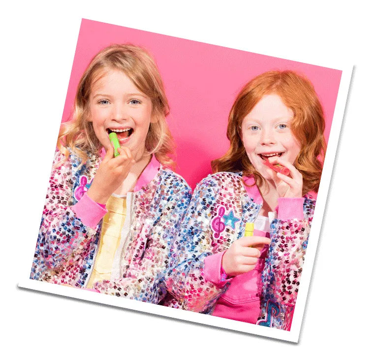 Two young girls using chapsticks